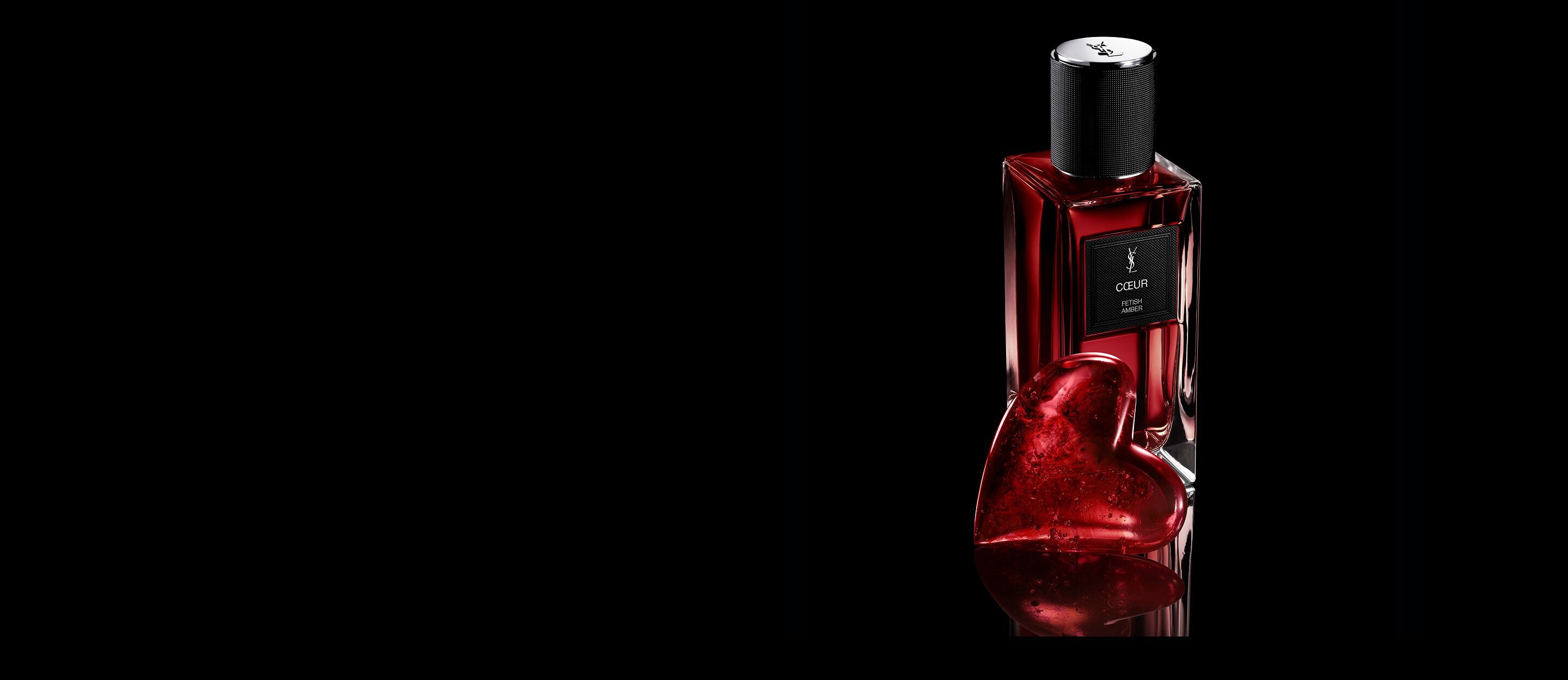 Flacon de CŒUR Eau de Parfum par YSL
à côté d’un bijou cœur rouge rubis sur une
surface noire réfléchissante.